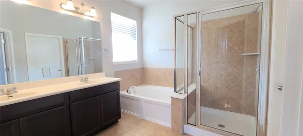 a bathroom with a tub shower and sink