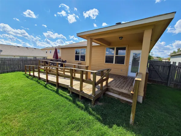 a view of a house with backyard and sitting area