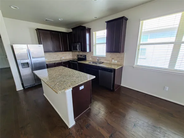a kitchen with granite countertop a stove and a refrigerator