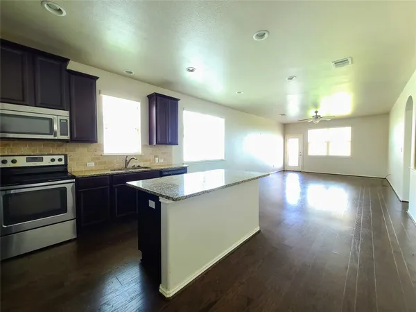 a kitchen with stainless steel appliances granite countertop a stove a sink and a microwave