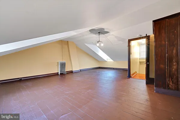 a spacious bedroom with a bed and wooden floor