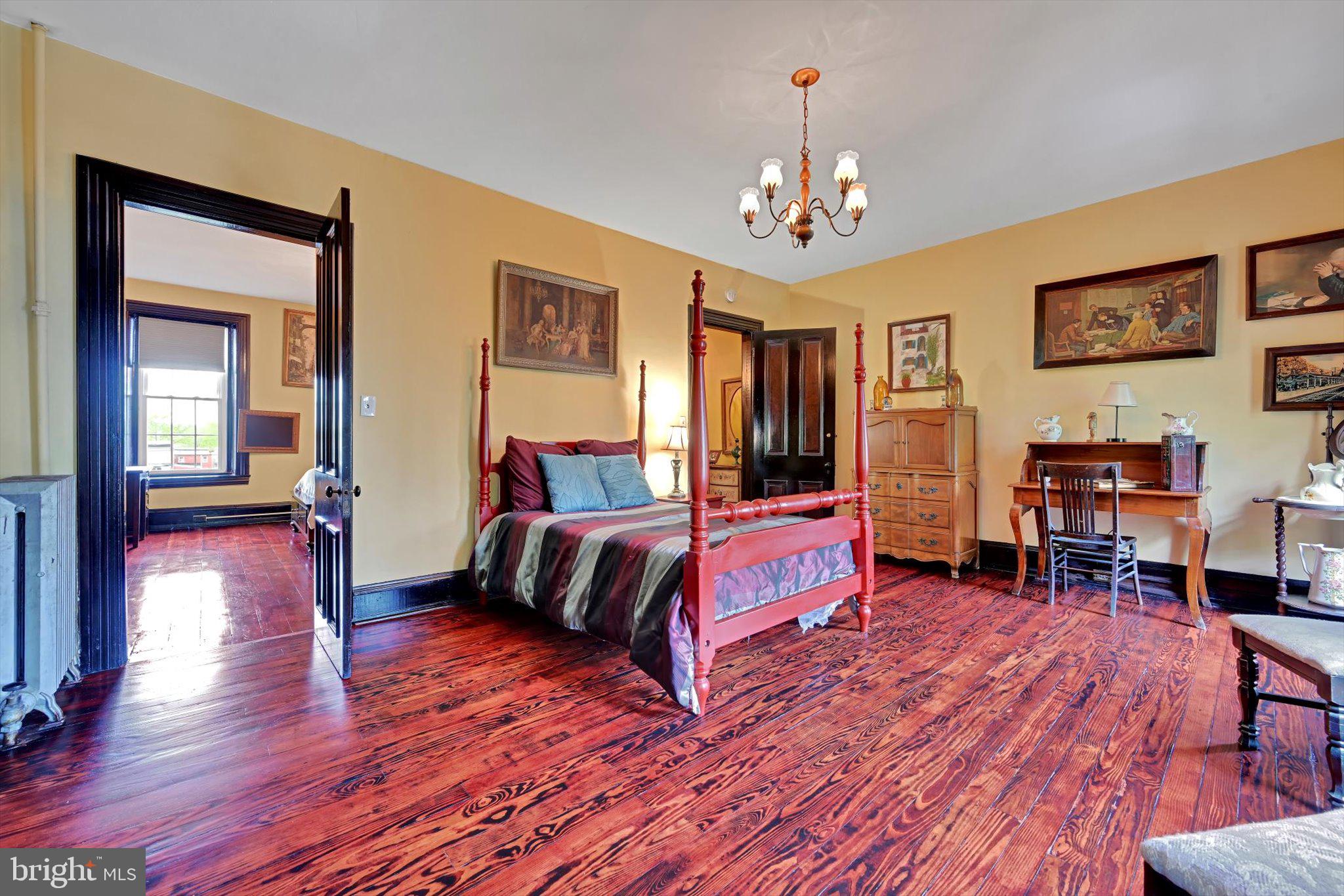 226 South 5th Street Reading, PA 19602 - Photo 25 of 47 a spacious bedroom with a bed and a chandelier