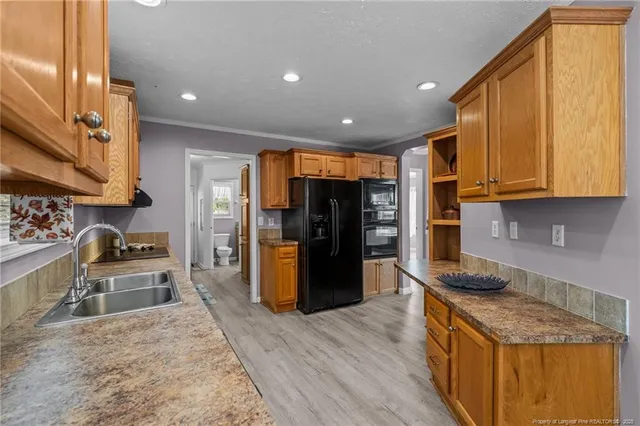 a kitchen with stainless steel appliances granite countertop a refrigerator stove top oven and sink