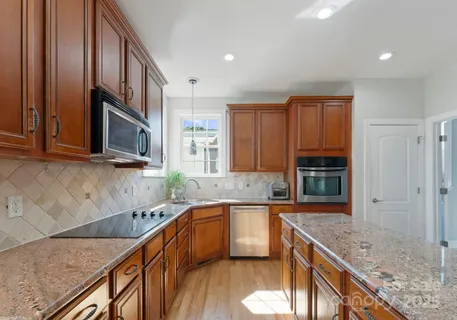 a kitchen with stainless steel appliances granite countertop a sink stove and cabinets