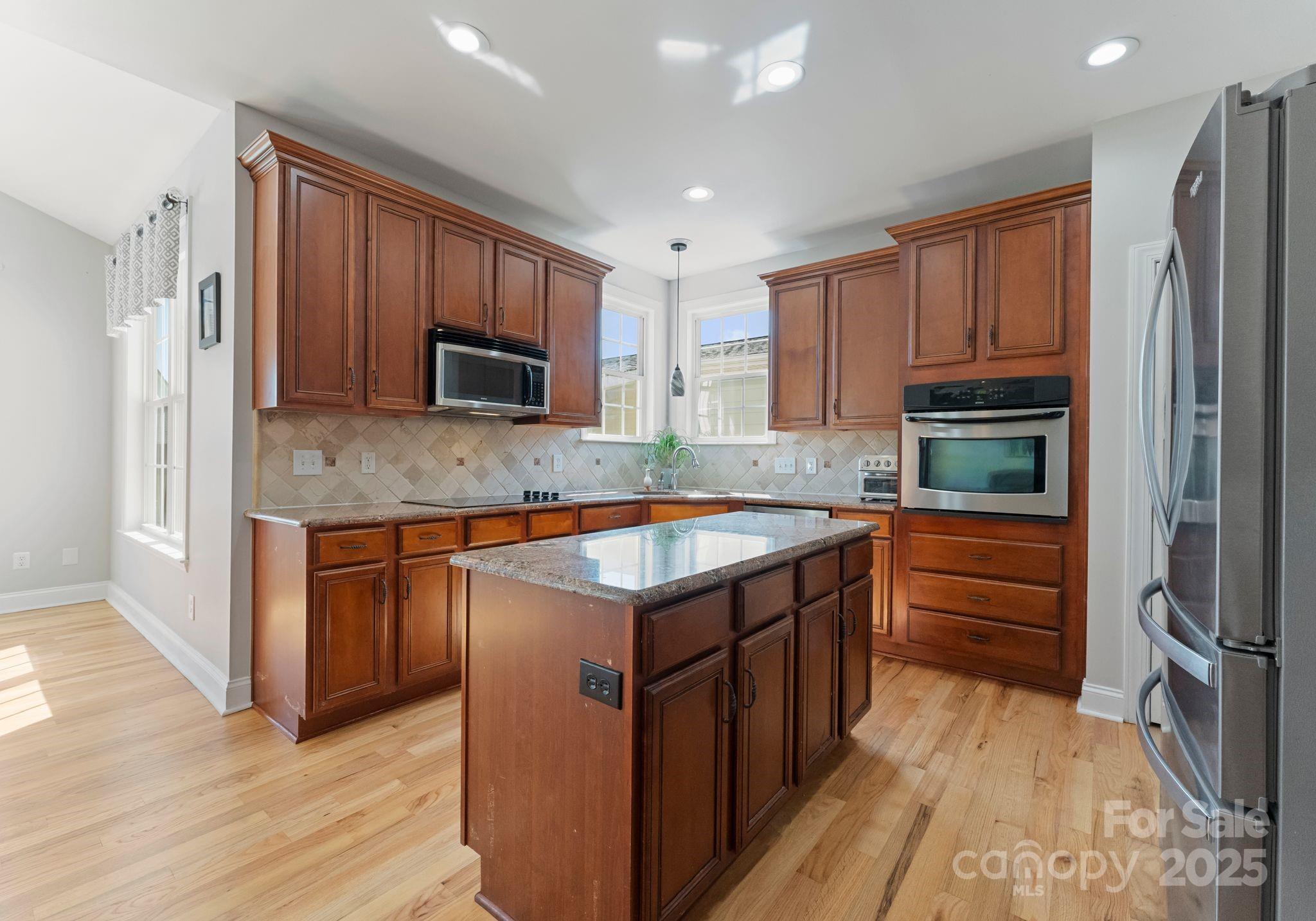 895 East Monbo Road Statesville, NC 28677 - Photo 18 of 44 a kitchen with kitchen island granite countertop wooden cabinets stainless steel appliances and a granite counter tops