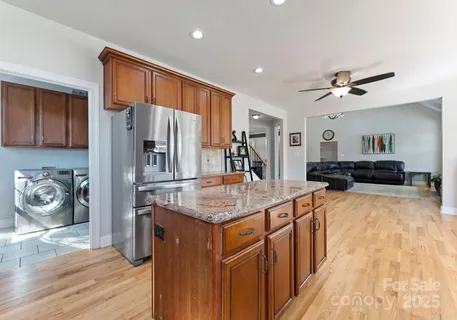 a kitchen with stainless steel appliances granite countertop a refrigerator a stove and a sink