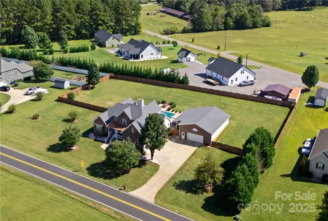 an aerial view of a house with a garden and lake view