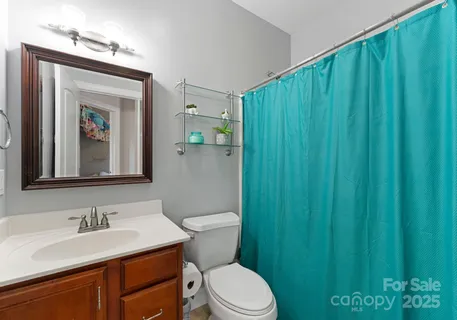 a bathroom with a toilet a sink and mirror