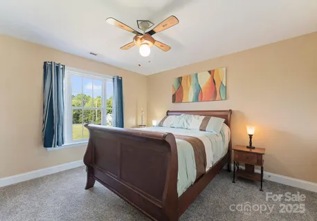 a bed sitting in a spacious bedroom next to a window