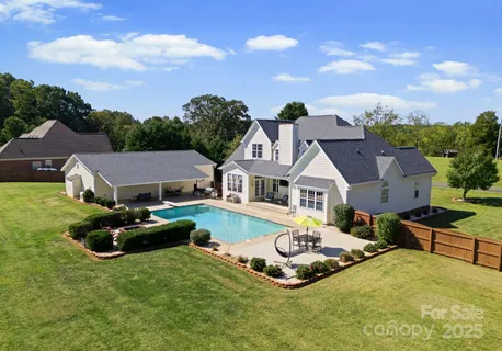 a front view of house with yard and trees in the background