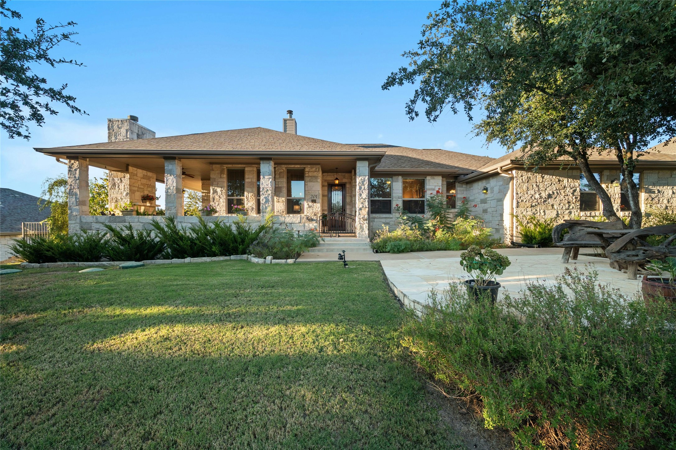 201 Greenridge Lane Dripping Springs, TX 78620 - Photo 24 of 29 View of front of home featuring a chimney, a front lawn, covered porch, and stone siding
