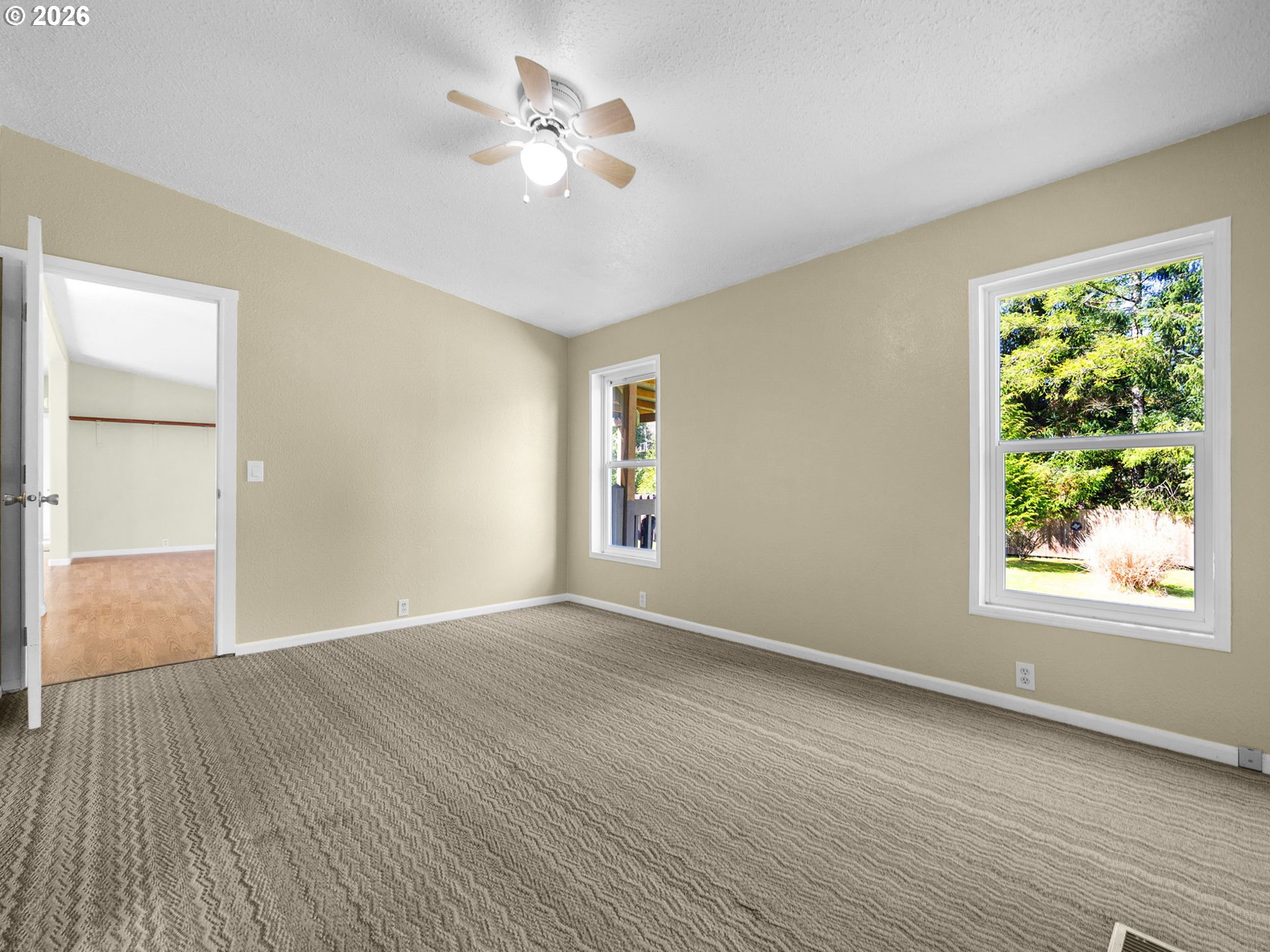 44176 Highway 30 Astoria, OR 97103 - Photo 19 of 32 an empty room with wooden floor chandelier fan and windows