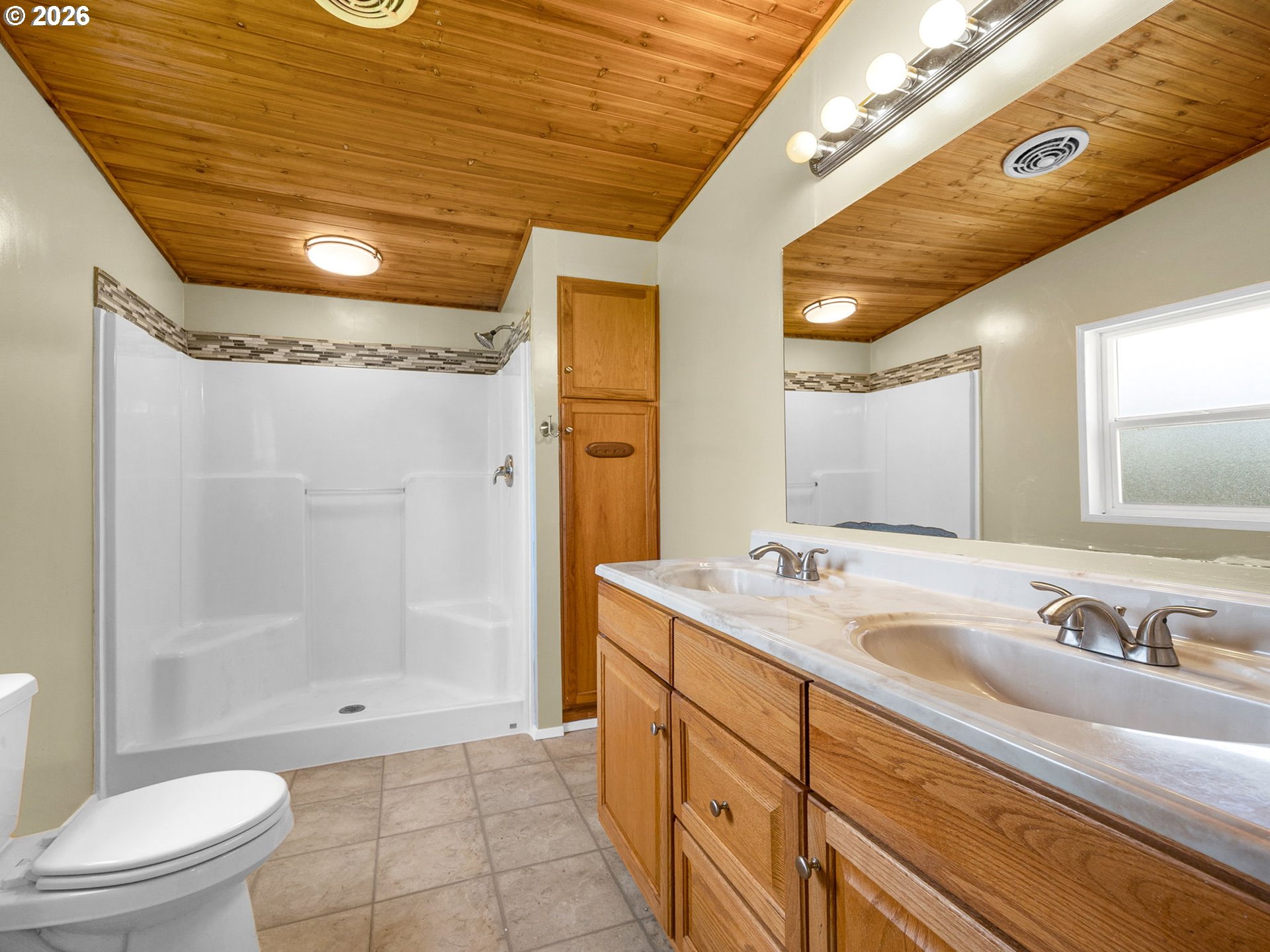 44176 Highway 30 Astoria, OR 97103 - Photo 21 of 32 a spacious bathroom with a granite countertop sink a toilet a mirror and shower