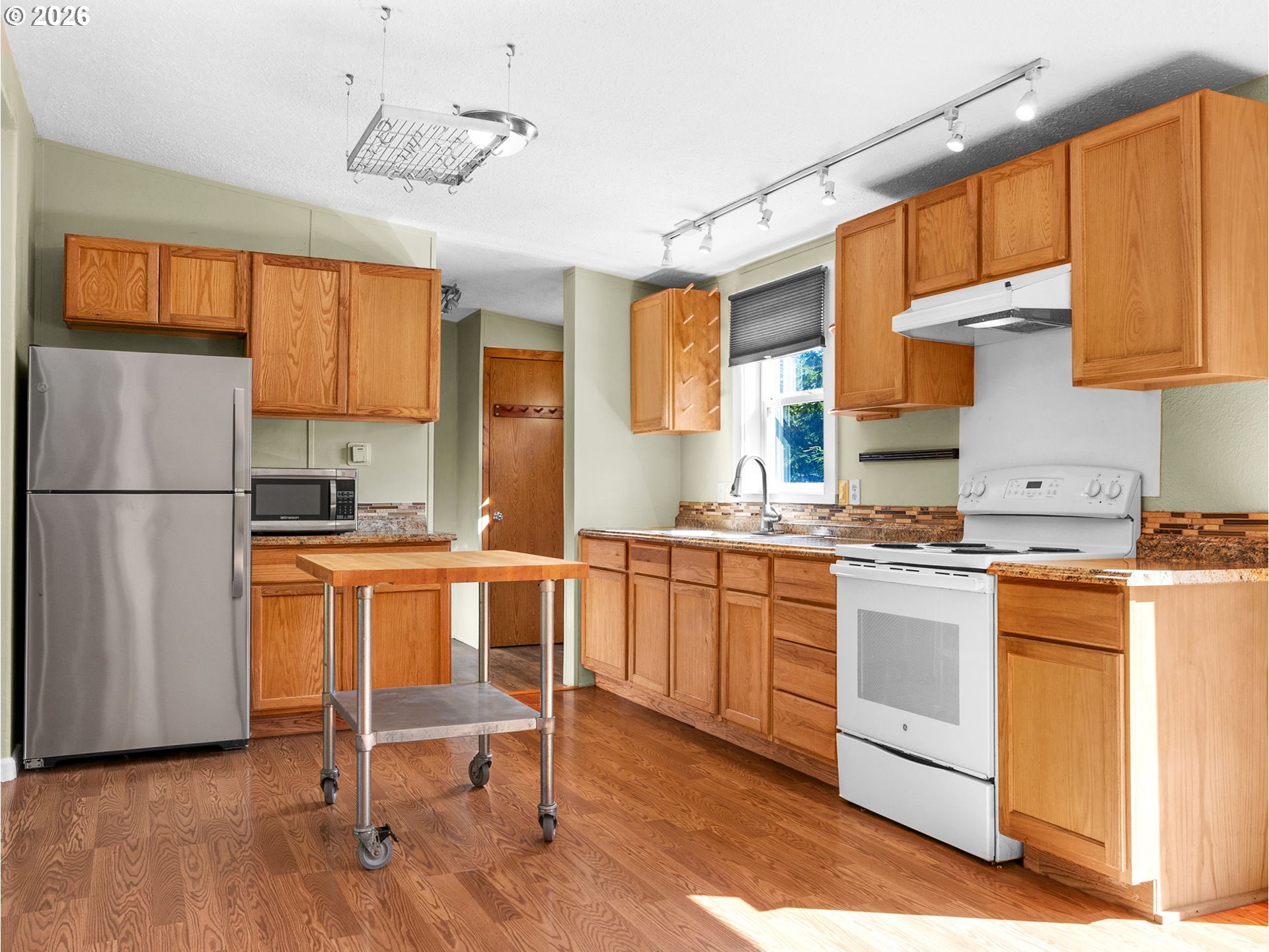44176 Highway 30 Astoria, OR 97103 - Photo 9 of 32 a kitchen with stainless steel appliances granite countertop a refrigerator a sink dishwasher a stove and white cabinets with wooden floor
