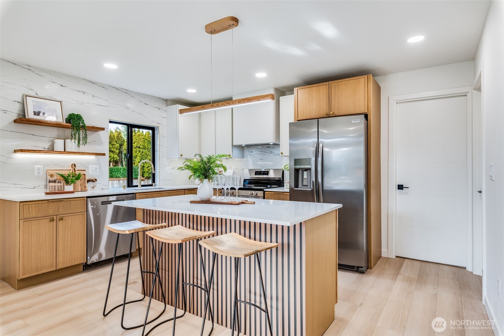 4922 Northeast 20th Place Renton, WA 98059 - Photo 7 of 38 a kitchen with kitchen island granite countertop a stove a refrigerator a sink a dining table and chairs