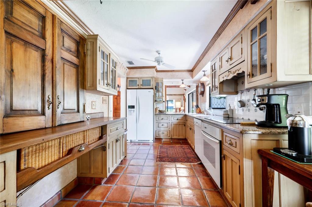839 Reef Point Circle, Unit 41 Naples, FL 34108 - Photo 17 of 37 a kitchen with stainless steel appliances kitchen island granite countertop a refrigerator a stove and a sink with wooden floor