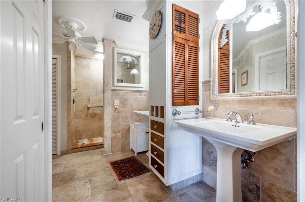 839 Reef Point Circle, Unit 41 Naples, FL 34108 - Photo 20 of 37 a bathroom with a sink a mirror and a shower