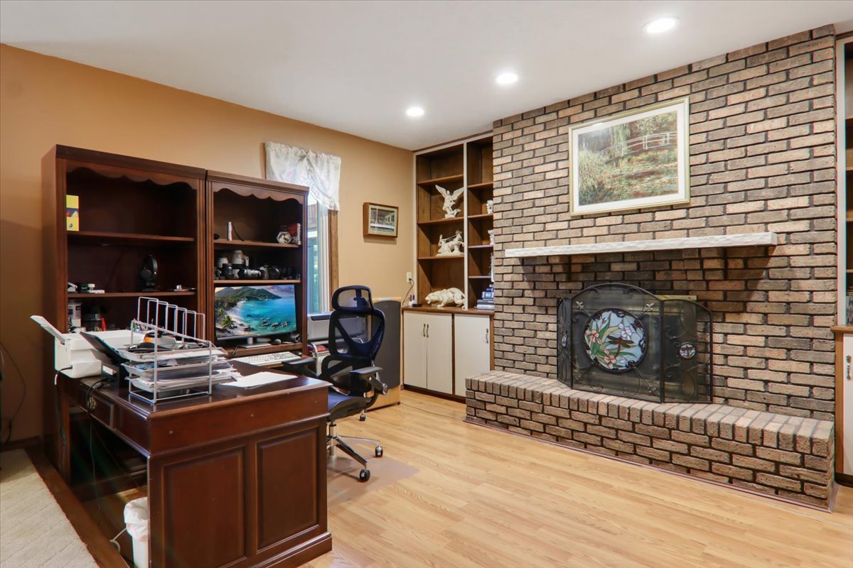 2215 Woodfield Road Bloomington, IL 61704 - Photo 14 of 35 a living room with fireplace furniture and a wooden floor