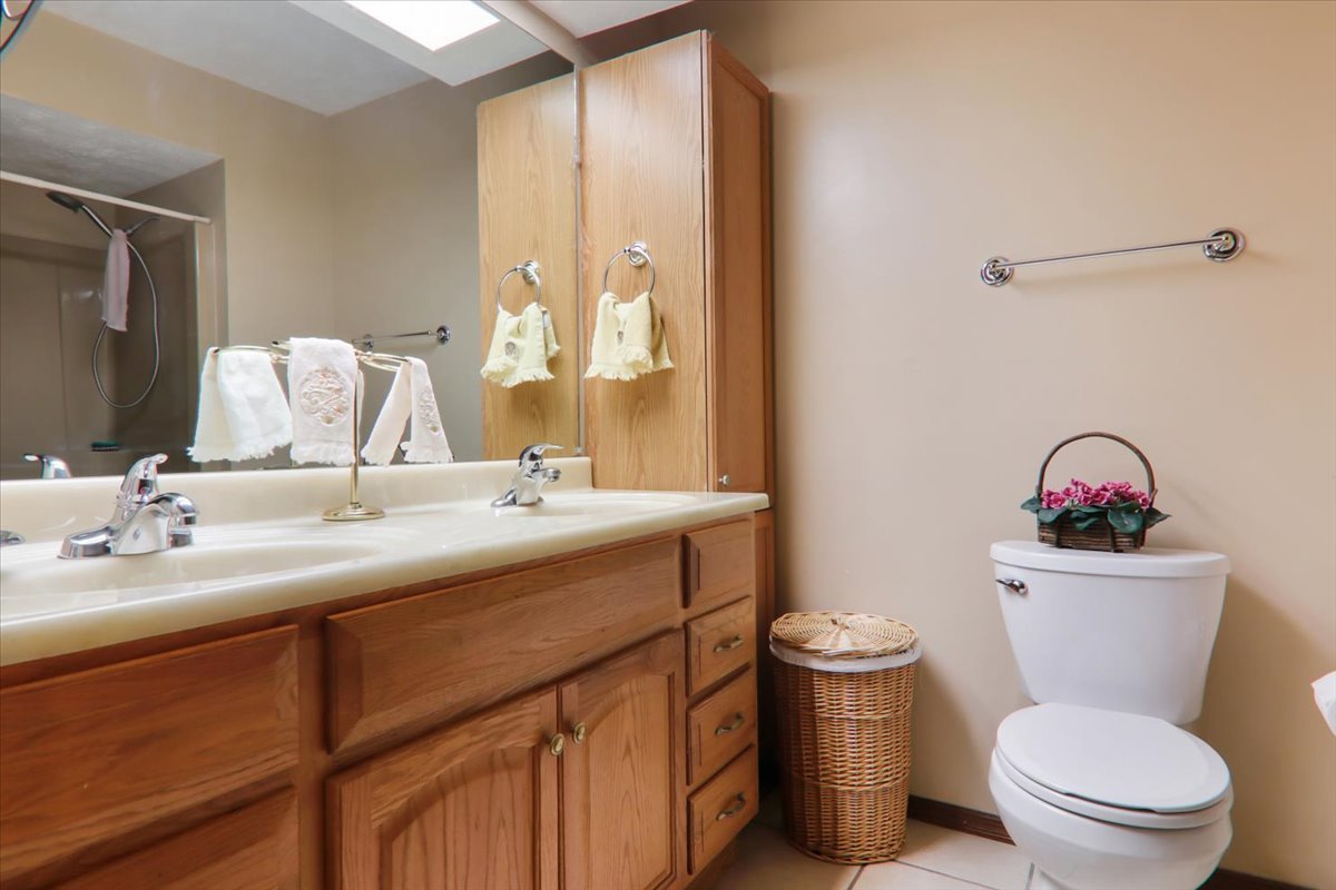 2215 Woodfield Road Bloomington, IL 61704 - Photo 17 of 35 a bathroom with a toilet sink and mirror
