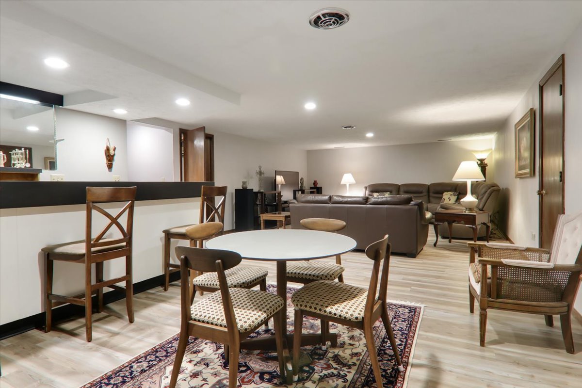 2215 Woodfield Road Bloomington, IL 61704 - Photo 21 of 35 a kitchen with stainless steel appliances kitchen island granite countertop a dining table chairs and a refrigerator