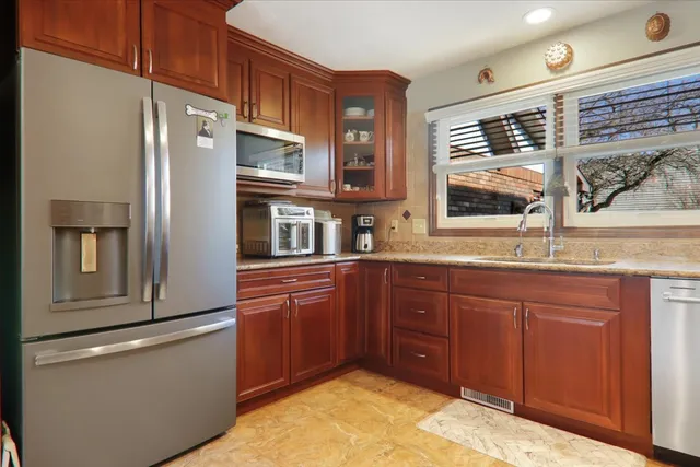 a kitchen with stainless steel appliances granite countertop a refrigerator and a sink