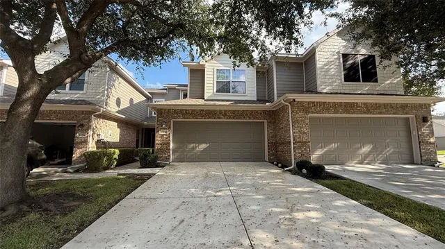 a front view of a house with a yard and a garage
