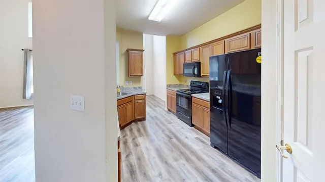 a kitchen with stainless steel appliances granite countertop a refrigerator and a stove