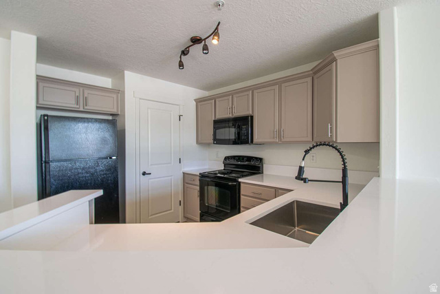 4276 South Main Street, Unit 303 Murray, UT 84107 - Photo 2 of 20 Kitchen featuring light-toned cabinetry, light countertops, and track lighting