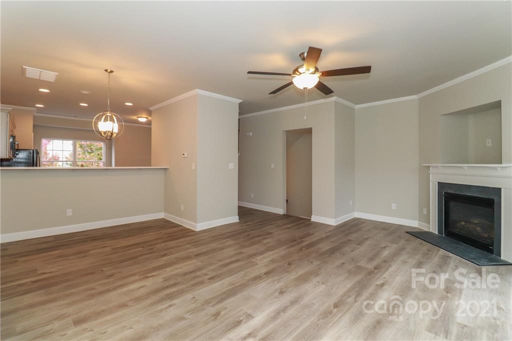 1265 Amber Ridge Road Northwest Concord, NC 28027 - Photo 11 of 26 a view of an empty room with wooden floor and a fireplace