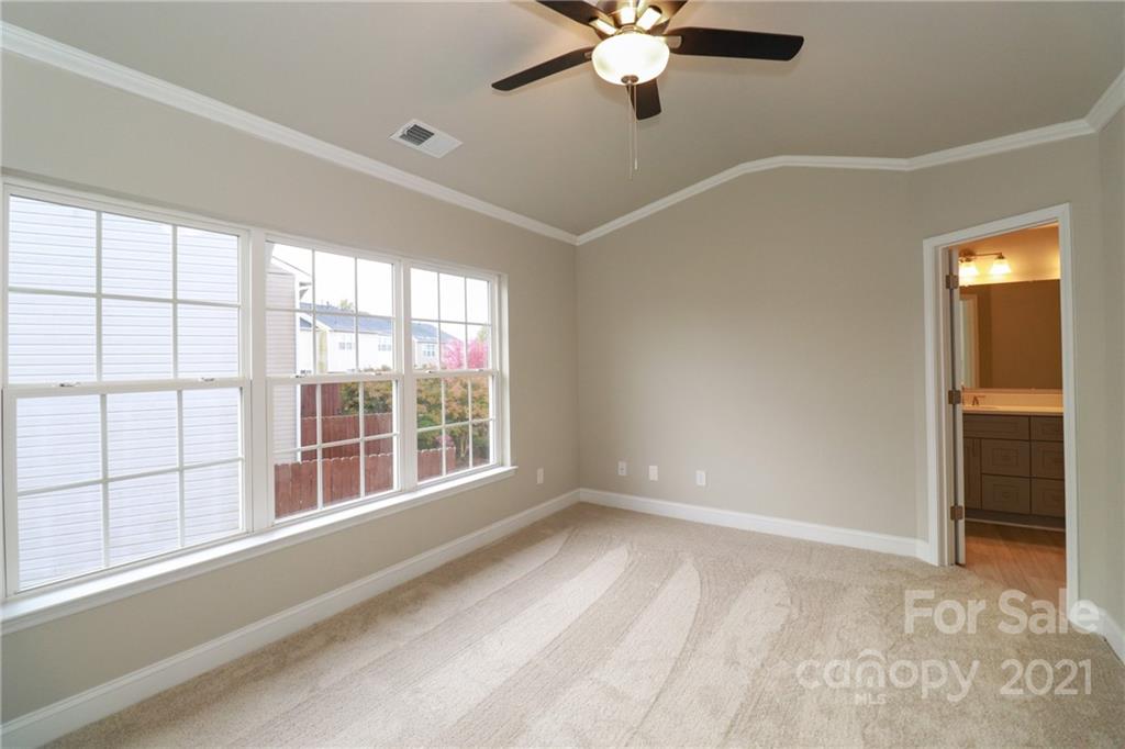 1265 Amber Ridge Road Northwest Concord, NC 28027 - Photo 20 of 26 an empty room with chandelier fan and windows