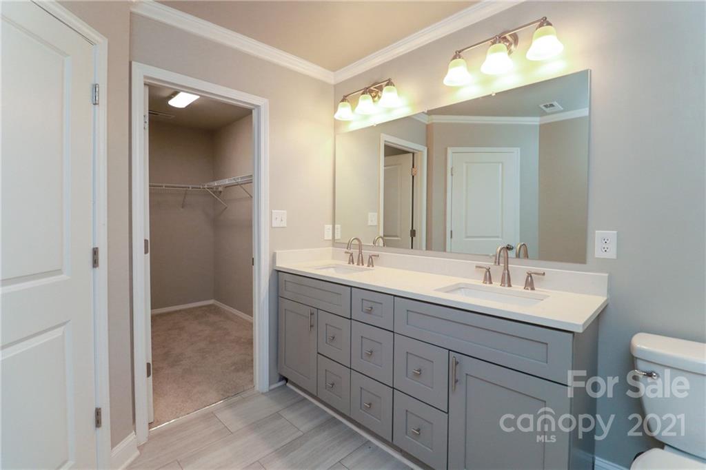 1265 Amber Ridge Road Northwest Concord, NC 28027 - Photo 22 of 26 a bathroom with a double vanity sink and mirror