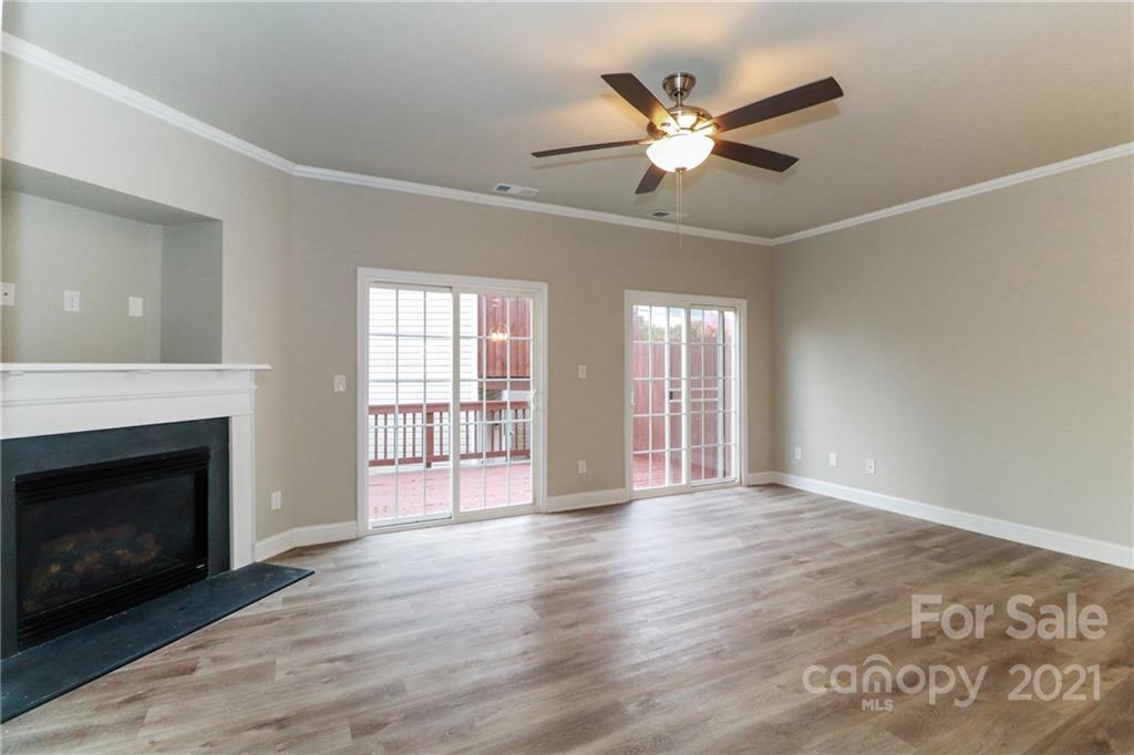 1265 Amber Ridge Road Northwest Concord, NC 28027 - Photo 9 of 26 a view of an empty room with wooden floor and a fireplace