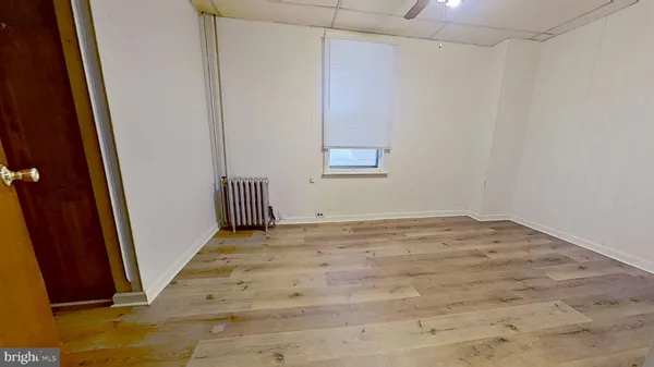 a view of a room with wooden floor and a bathroom
