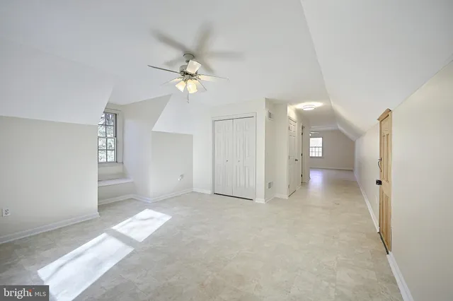 a view of a big room with chandelier fan and windows