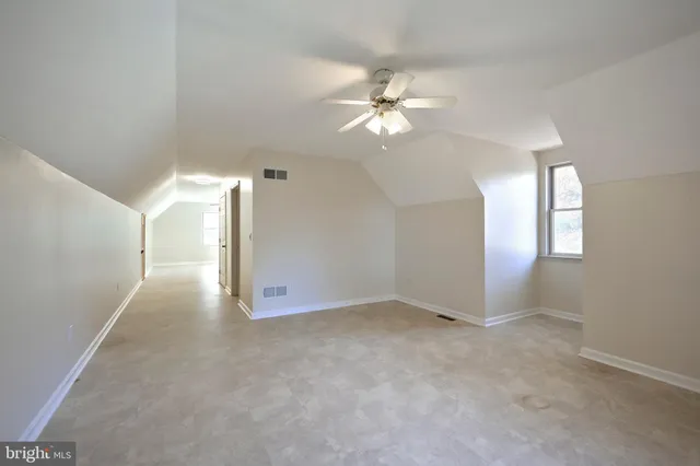 an empty room with fan and windows