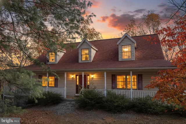 a front view of a house with plants and trees