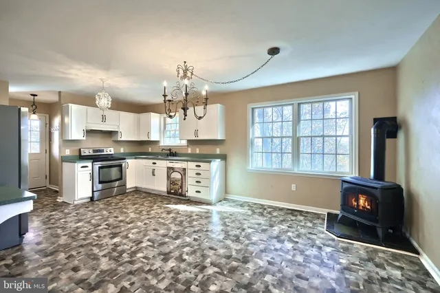 a kitchen with granite countertop a stove a sink and a refrigerator