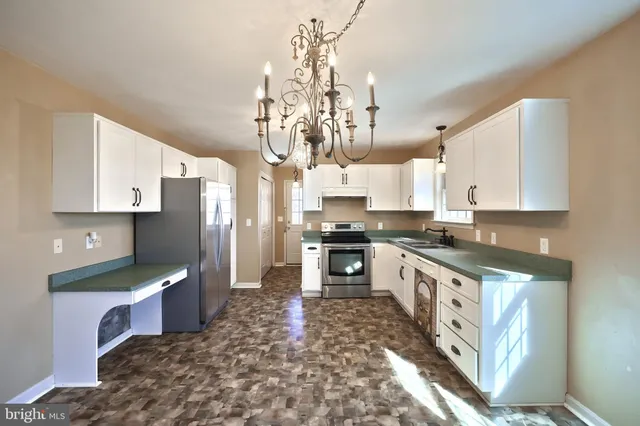 a large kitchen with stainless steel appliances kitchen island granite countertop a sink and cabinets