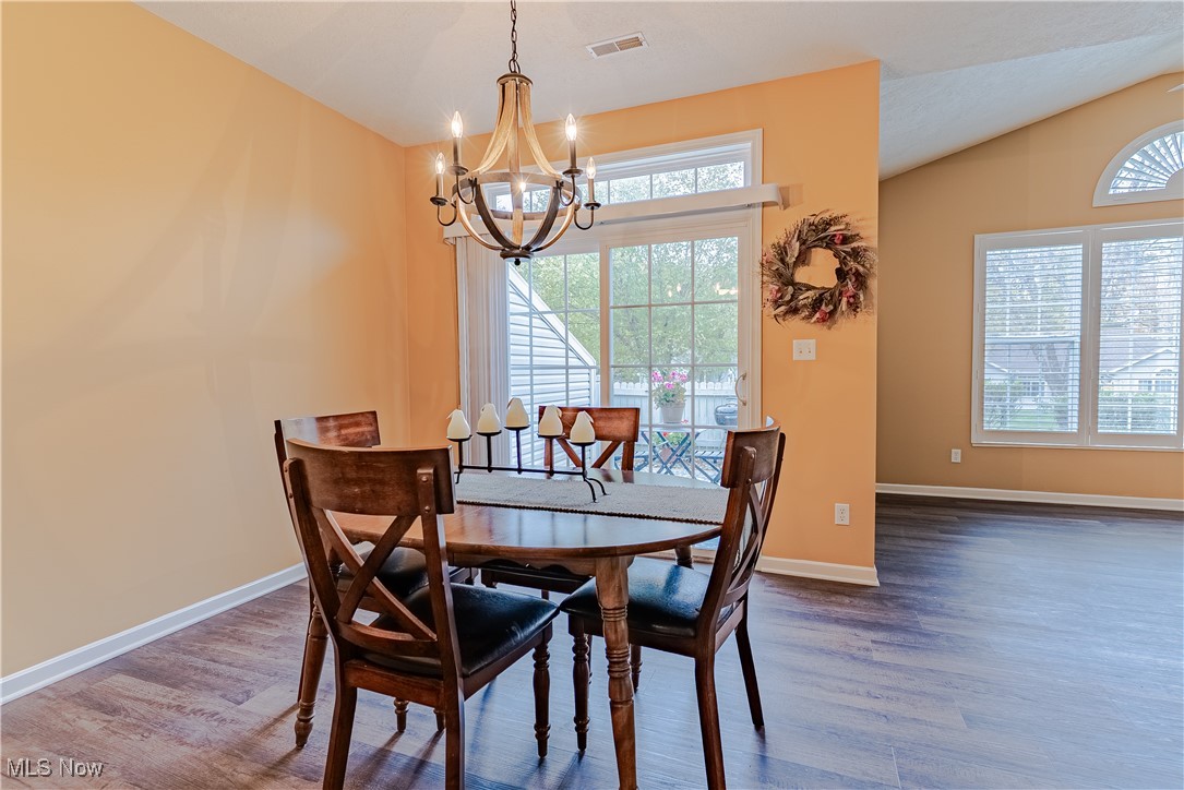 5645 Clingan Road, Unit 23B Struthers, OH 44471 - Photo 14 of 38 Dining space featuring wood finished floors, lofted ceiling, and a chandelier