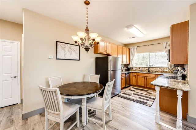 a view of a dining room with furniture a chandelier and wooden floor