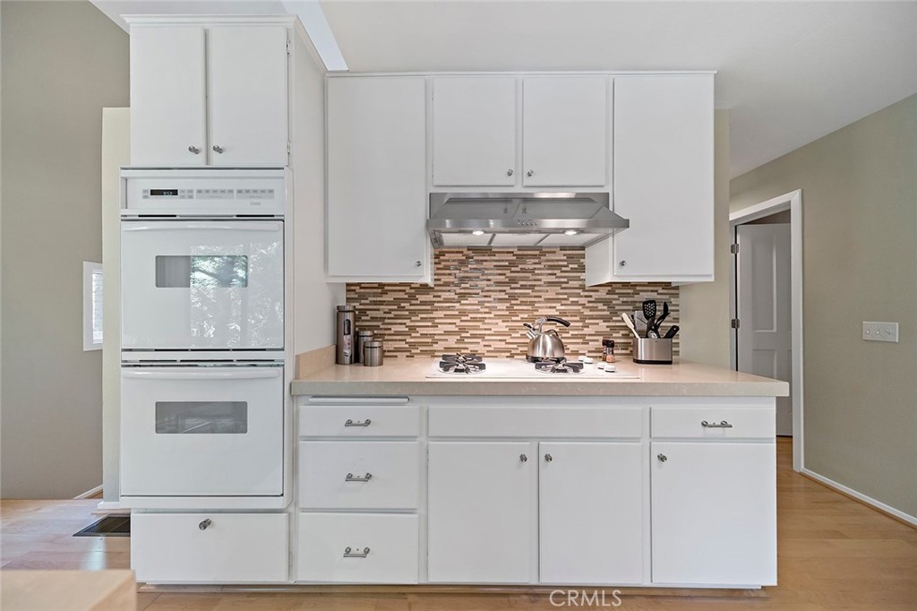 612 Karenken Pines Drive Lake Arrowhead, CA 92391 - Photo 14 of 44 a kitchen with white cabinets and a refrigerator