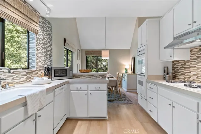 a kitchen with white cabinets and white appliances