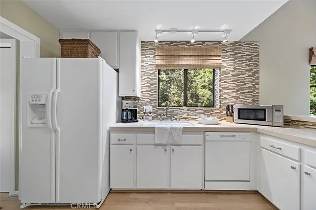 a kitchen with white cabinets and white appliances