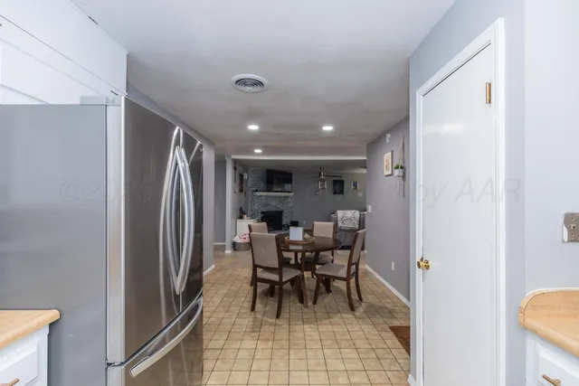 a view of a hallway with chairs and a refrigerator
