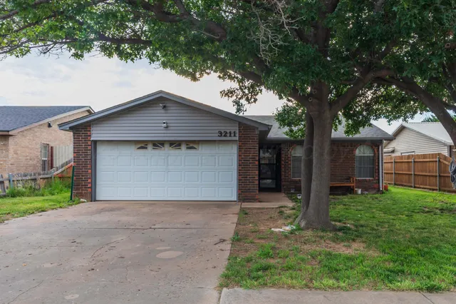 a front view of house with yard and trees