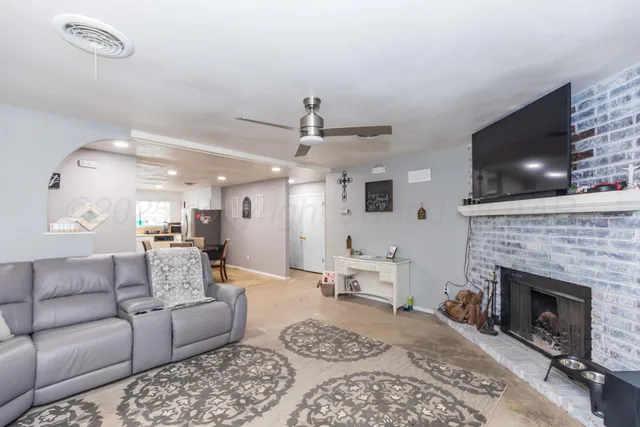 a living room with furniture a flat screen tv and a fireplace