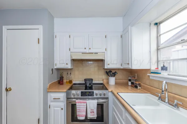 a kitchen with stainless steel appliances granite countertop a sink stove and cabinets