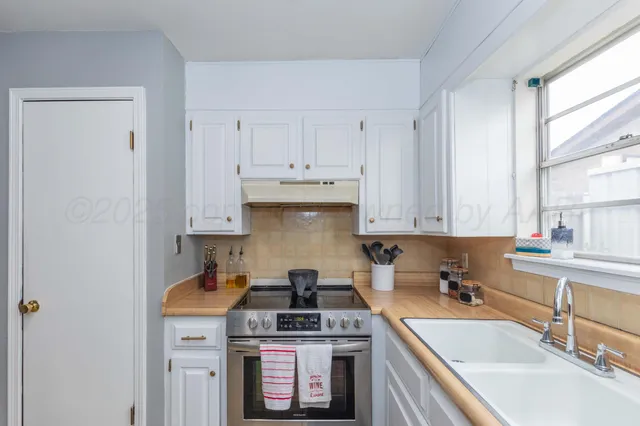 a kitchen with stainless steel appliances granite countertop a sink stove and cabinets