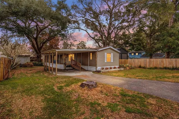 a view of a yard with a house and a large tree