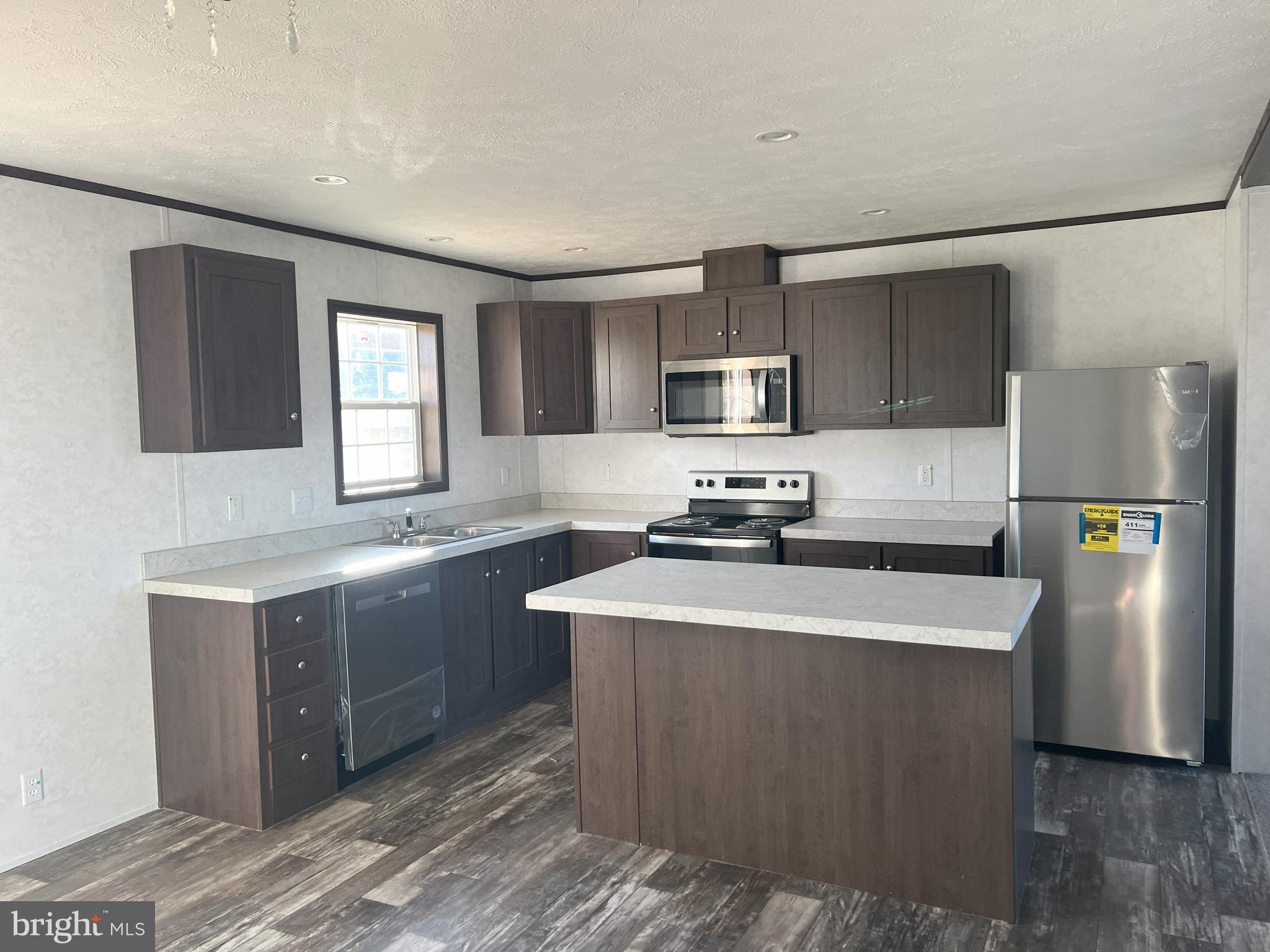 211 Eisenhower Road Moorefield, WV 26836 - Photo 4 of 17 a kitchen with stainless steel appliances granite countertop a refrigerator a sink a stove a microwave a counter space and cabinets